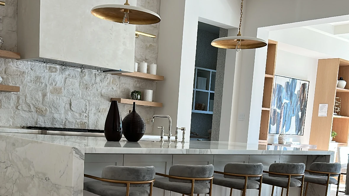 Finished residential kitchen with large stone island and pendant lighting