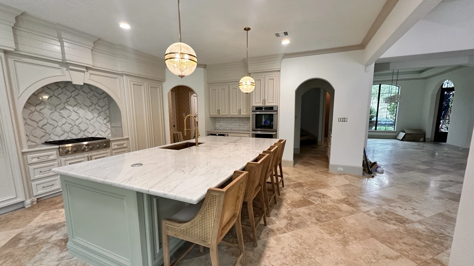 Large residential kitchen with stone island and pendant lighting