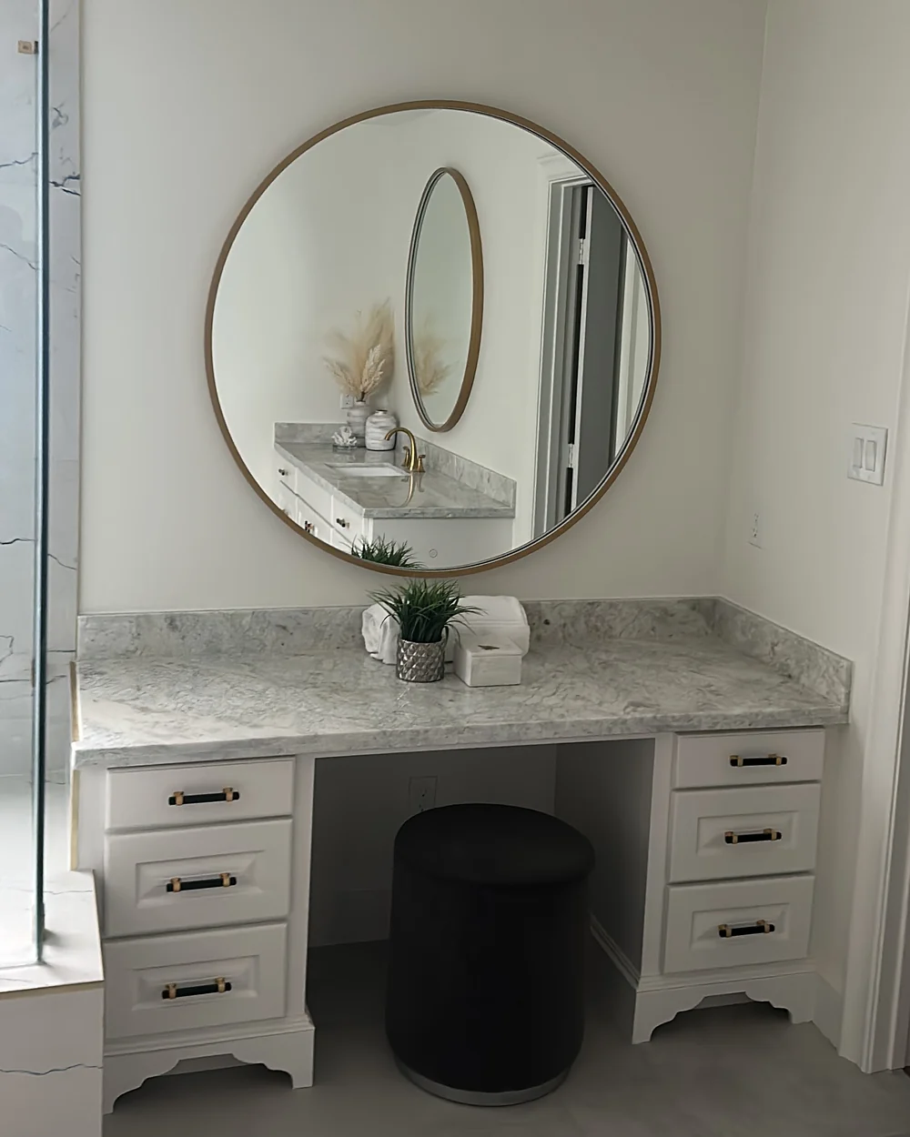 Large round mirror mounted above a bathroom vanity