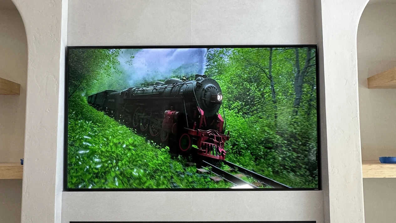 Large television mounted above a modern linear fireplace