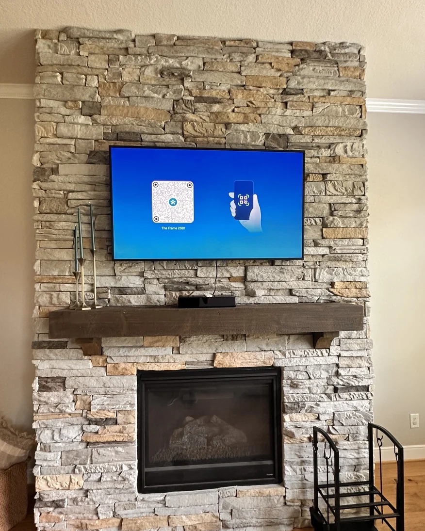 Television mounted on a stacked-stone fireplace