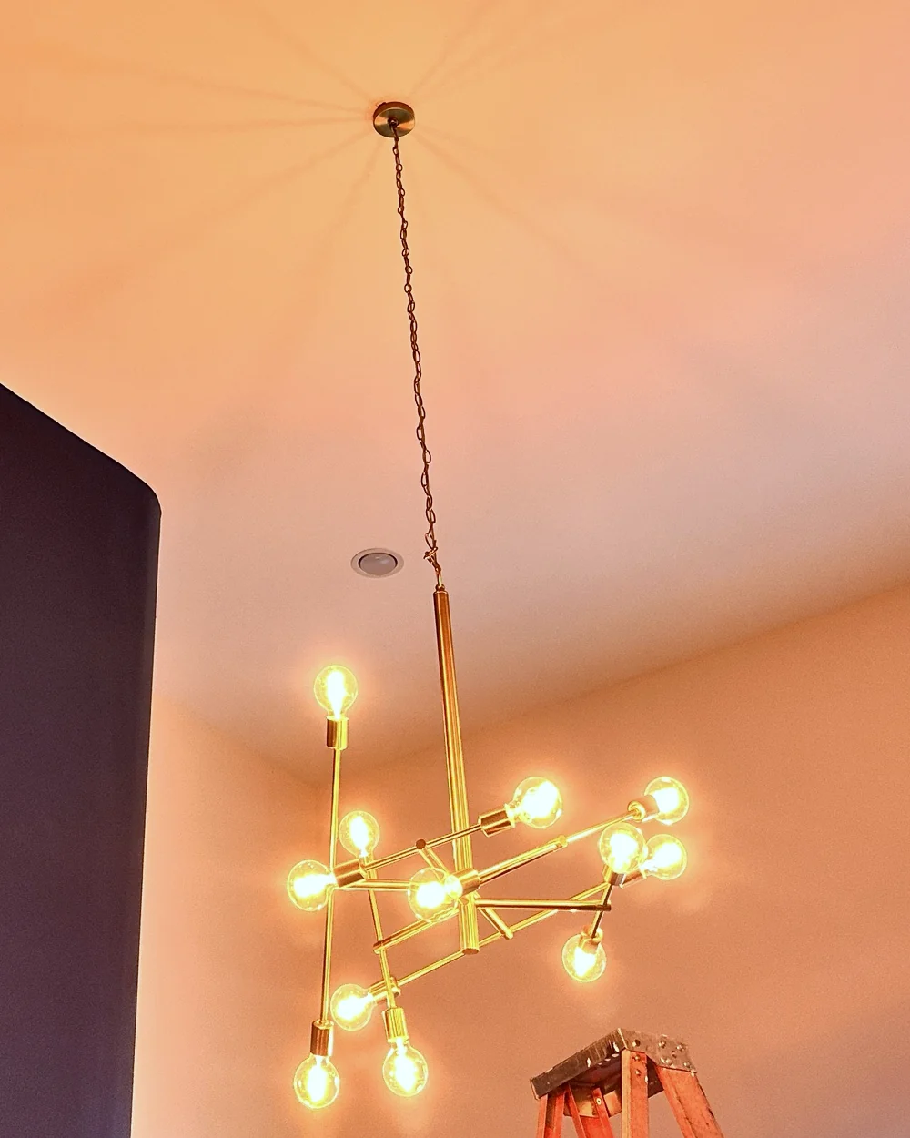 Brass sputnik chandelier installed on the same vaulted ceiling