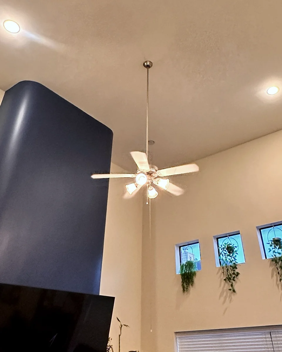Dated ceiling fan on a high vaulted living room ceiling